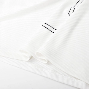 Detail view of white ribbed fabric featuring black linear accents and premium stitching