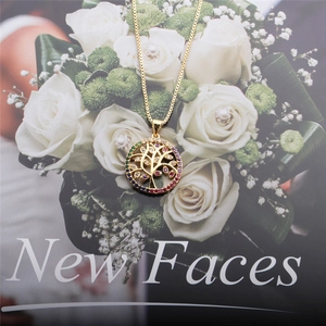 Golden Tree of Life necklace with colorful zircons on a white rose background