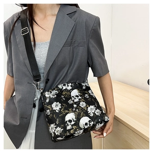 Detail of nylon crossbody bag featuring unique skull and floral print with adjustable strap