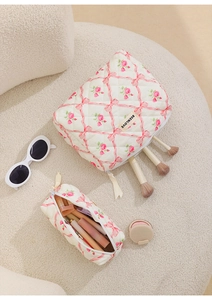 Detail of quilted floral makeup bags in two sizes with pink ribbon and flower patterns