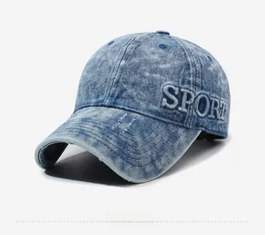 Close-up of white SPORT letter embroidery on washed blue denim vintage baseball cap