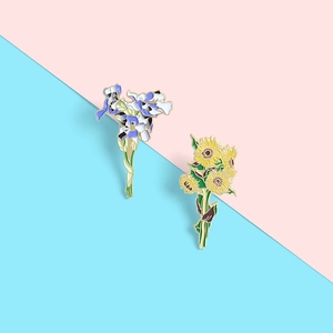 Detailed close-up of Van Gogh sunflower and iris enamel pins with polished finish