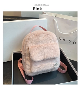 Vista de detalle de mini mochila rosa de felpa con piel sintética suave y parche decorativo