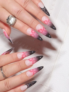 Long stiletto press-on nails with pink to black gradient, hearts and starburst designs