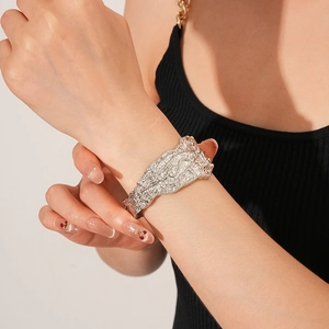 Dettaglio del bracciale rigido argento largo con texture a pieghe irregolari