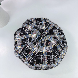Detail of colorful plaid tweed beret showing retro woven wool fabric and top button