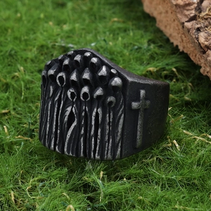 Macro detail of gothic monk portrait and cross pattern on aged steel ring