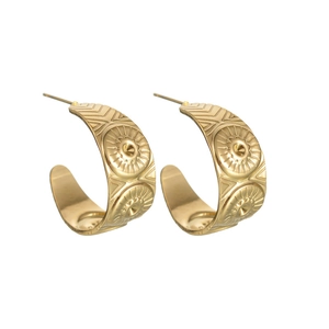 Detailed view of golden C-shaped earrings with vintage sunburst patterns on white background