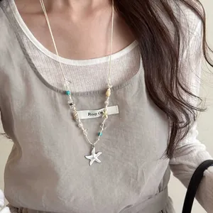 Detailed close-up of starfish pendant necklace with shell and bead accents for summer vacation