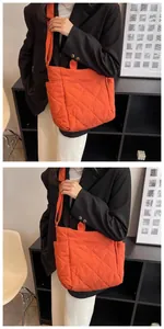Detail view of orange quilted tote bag showing side pocket and diamond stitching