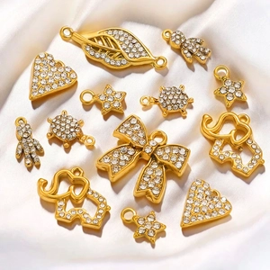 Close-up of gold-plated charms with rhinestones including hearts and animals