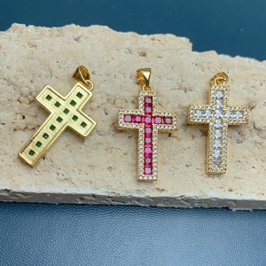 Detailed view of 18k gold-plated cross pendants with emerald and ruby zircon stones