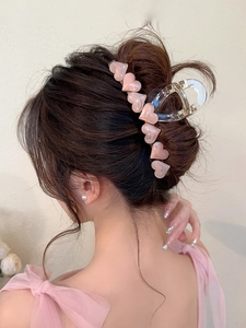 Detail of pink marble heart claw clip worn on hair with premium jelly texture finish