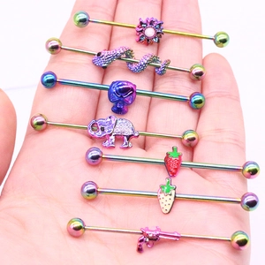 Gros plan de piercings industriels arc-en-ciel avec breloques serpent et fraise