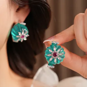 Vintage floral stud earrings with turquoise resin petals and red crystal center accents
