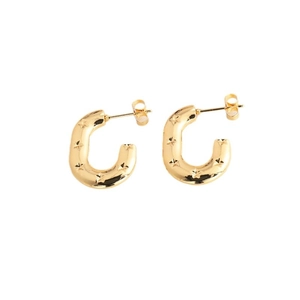 Polished gold C-shaped hoop earrings with embossed star pattern on a white background