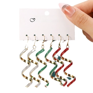 Three pairs of spiral drop earrings in silver, green, and red glitter on jewelry card
