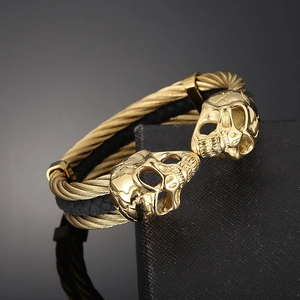 Macro shot of gold skull leather bracelet with metallic twisted rope on a display box