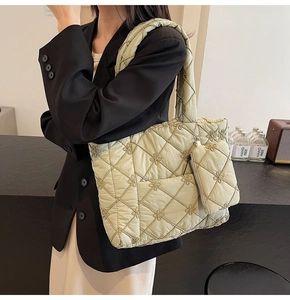 Detail of light green quilted tote bag with floral embroidery and small matching pouch
