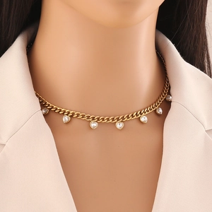 Golden chain necklace with colorful heart-shaped crystal pendants on a model