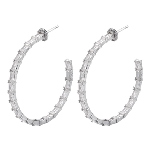 Detail of silver hoop earrings featuring baguette-cut zircon stones on a white background