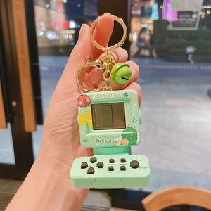 Dettaglio mini portachiavi console giochi dinosauro verde menta con campanello d'oro