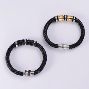 Men's punk woven leather bracelets with gold and silver metal rings on a grey surface