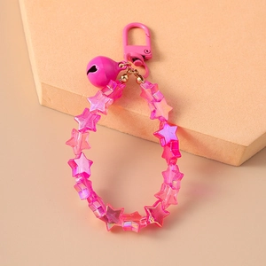 Macro shot of pink star beads and matching bell charm on a high-quality keychain detail