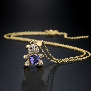 Collier ours doré avec pierre en cœur violet et zircons sur fond noir élégant