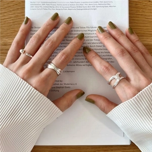 Close-up of S925 sterling silver knot rings and beaded bands on a female hand