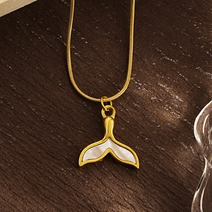 Elegant gold whale tail necklace with iridescent shell inlay on a wooden surface