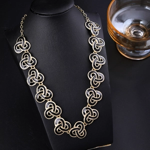 Vintage gold and black enamel necklace with celtic knot design on black mannequin