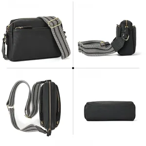 Detail view of black pebble leather crossbody bag with geometric woven strap and gold zippers