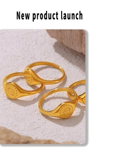 Detailed close-up of four gold sun-embossed signet rings on a textured stone surface
