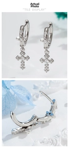 Détail macro de boucles d'oreilles croix en argent avec zircons et fermoir à charnière