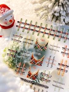 Detail of Christmas embossed nail stickers with red and green plaid and bow designs