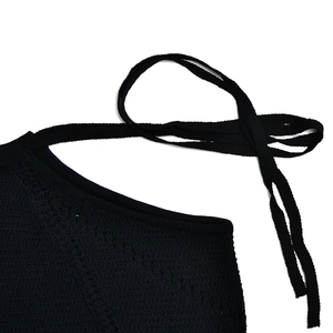 Dettaglio del cinturino in maglia nera e trama intrecciata di questo abito a schiena nuda