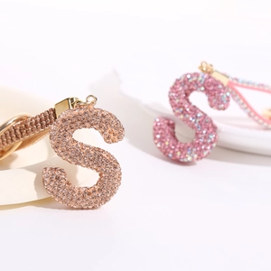 Luxury rhinestone-encrusted letter S keychain with woven strap and champagne gold plating
