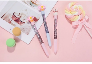 Detail of pink liquid glitter pens with cute cartoon toppers and sparkle flowing sand