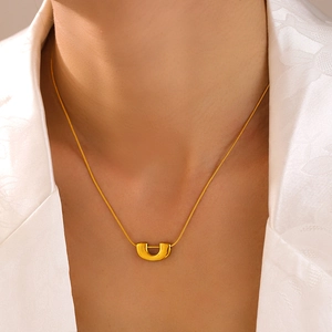 Minimalist gold-plated U-shaped pendant necklace on a model with a clean white background