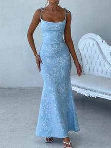 Detailed view of the textured light blue fabric and floor-length hem of the evening dress