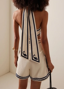 Detail view of cream halter top with navy trim and fish pattern on ties for summer