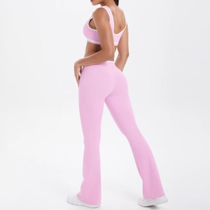 Detail of pink yoga set featuring sports bra and flared high-waisted leggings with white trim