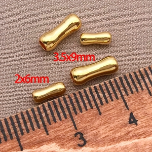 Vista macro di perline a botte in oro con misure di 3.5x9mm e 2x6mm per gioielli