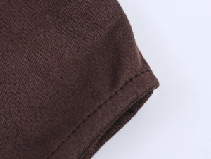 Gros plan sur le tissu en daim marron foncé montrant les coutures et la texture fine