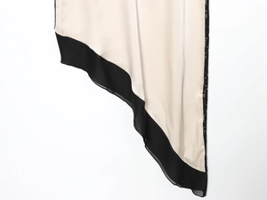 Detail eines Satin-Midikleides mit kontrastierender Wimpernspitze und Chiffonsaum