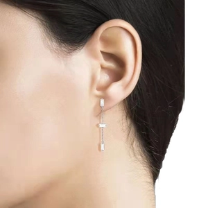 Elegant silver tassel earrings with baguette-cut crystals on model in minimalist style