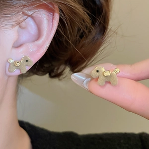 Detail view of brown flocked teddy dog stud earrings with gold accents and model display