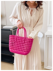 Close-up of rose red hollow woven jelly bag with detailed plastic texture and handles
