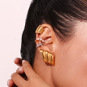 Close-up of layered 18K gold-plated textured ear cuffs and pearl clip-on earrings